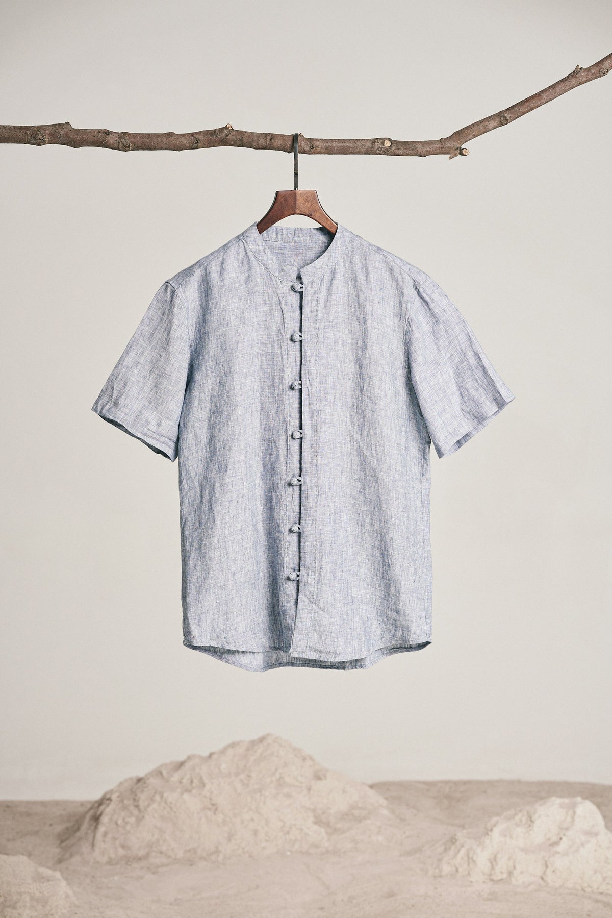 Grey band collar shirt hanging from a branch
